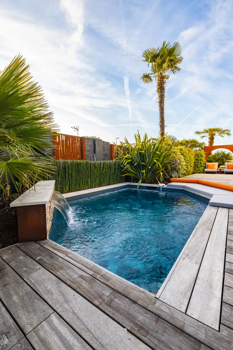 La piscine, sa plage en bois et l’arche corten