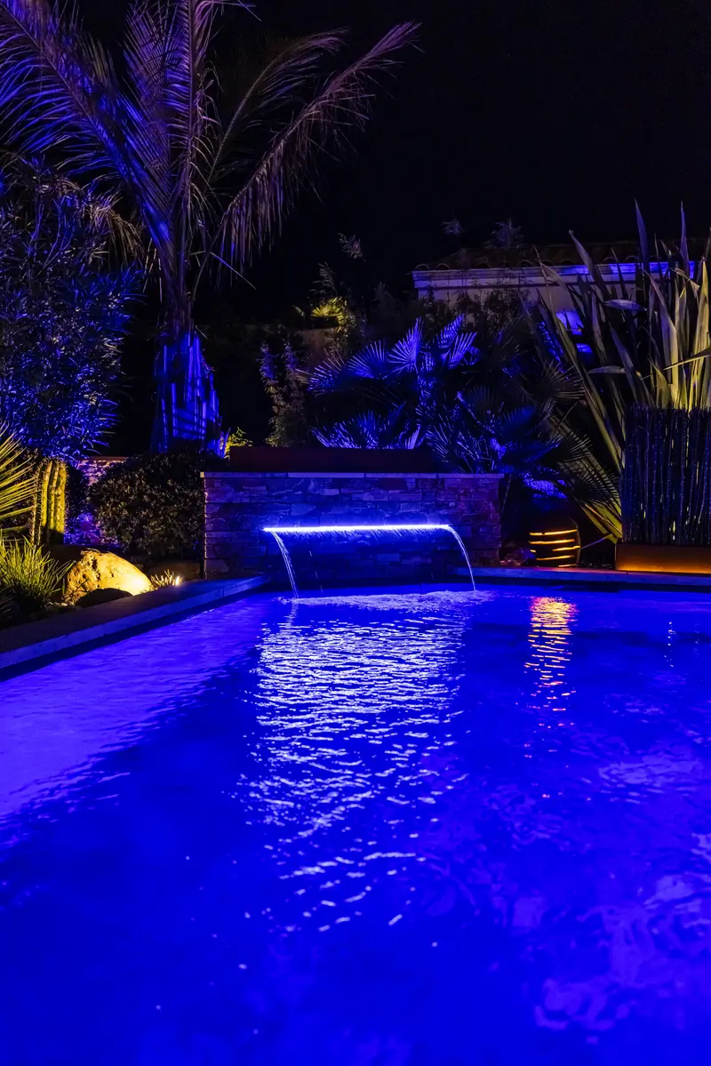 La piscine en bleu et sa cascade