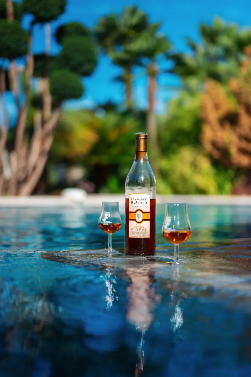 Une bouteille de Pineau Raymond Bossis et deux verres au bord de la piscine