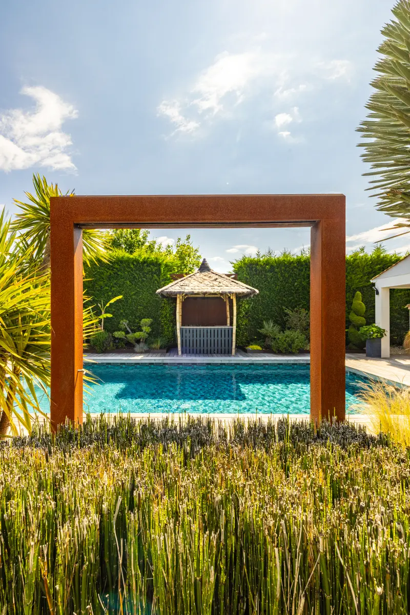 L’arche corten encadre la piscine et la paillote